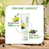 Organic Harvest skincare product with Kakadu Plum and Acai Berry ingredients on a wooden surface with greenery.
